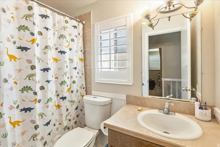 Recessed bathtub with shower rod, toilet, and vanity with built-in sink