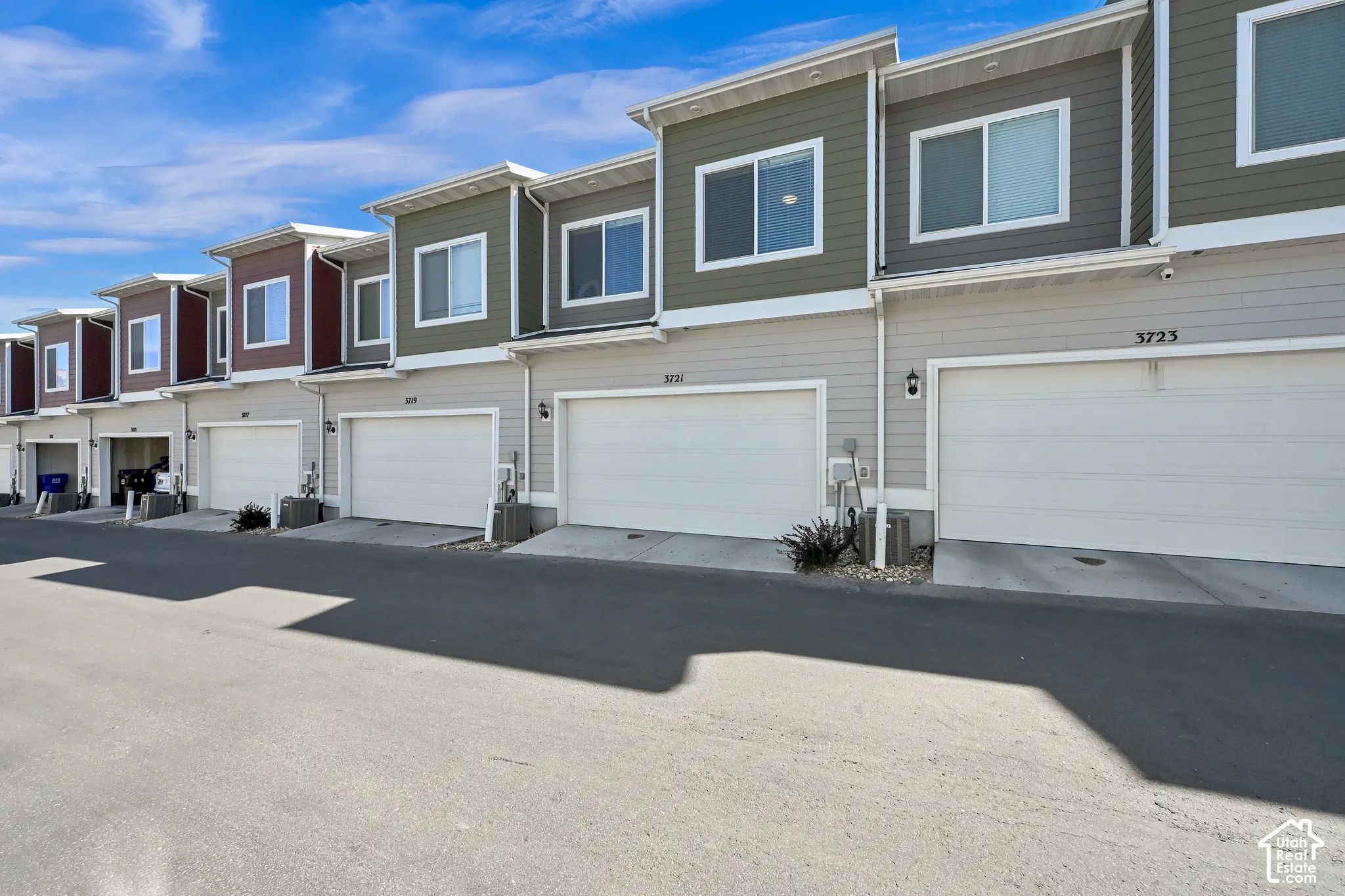 Modern townhome exteriors featuring horizontal siding, multiple windows, and attached garages