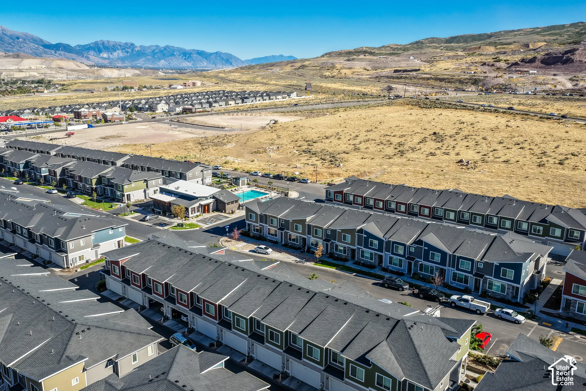 Community featuring multiple multi-story residential buildings, a central clubhouse, and an outdoor swimming pool