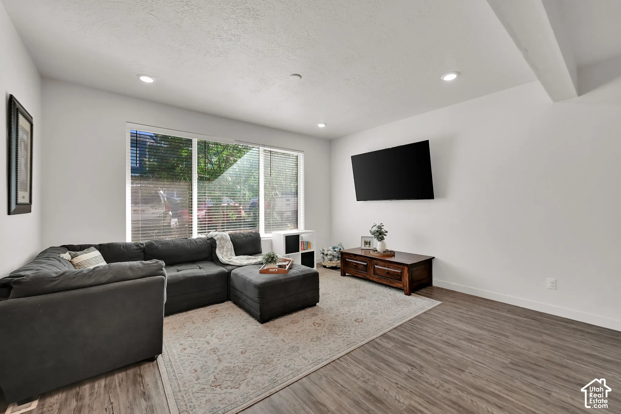 Recessed lighting, wood-finish flooring, and large windows with blinds