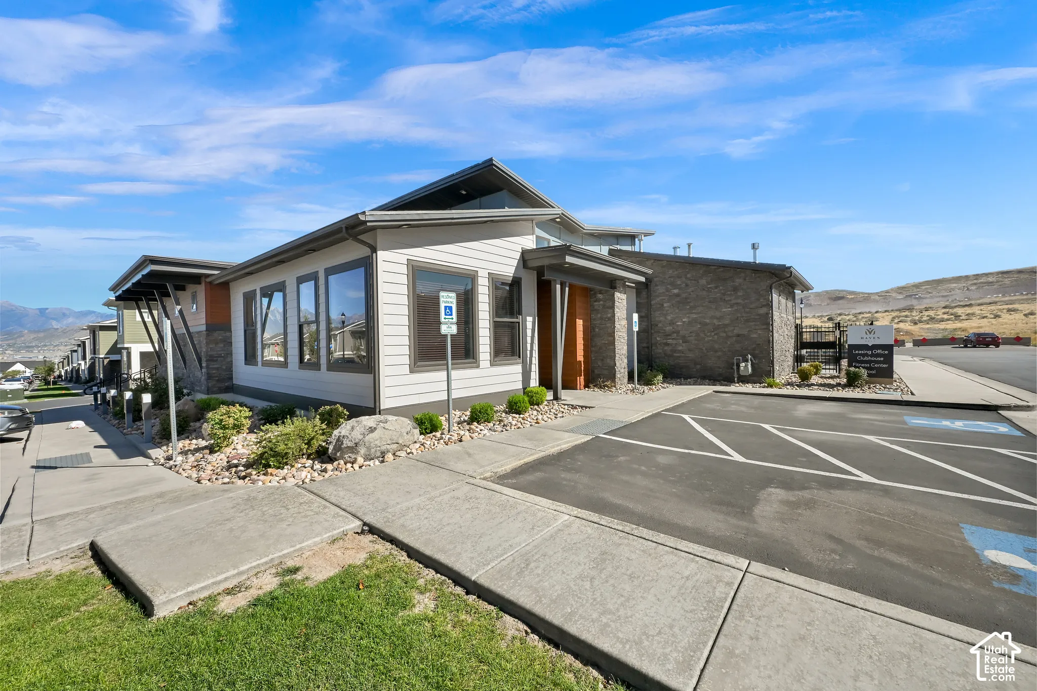 Contemporary architecture featuring large windows, stone accents, and a covered entrance