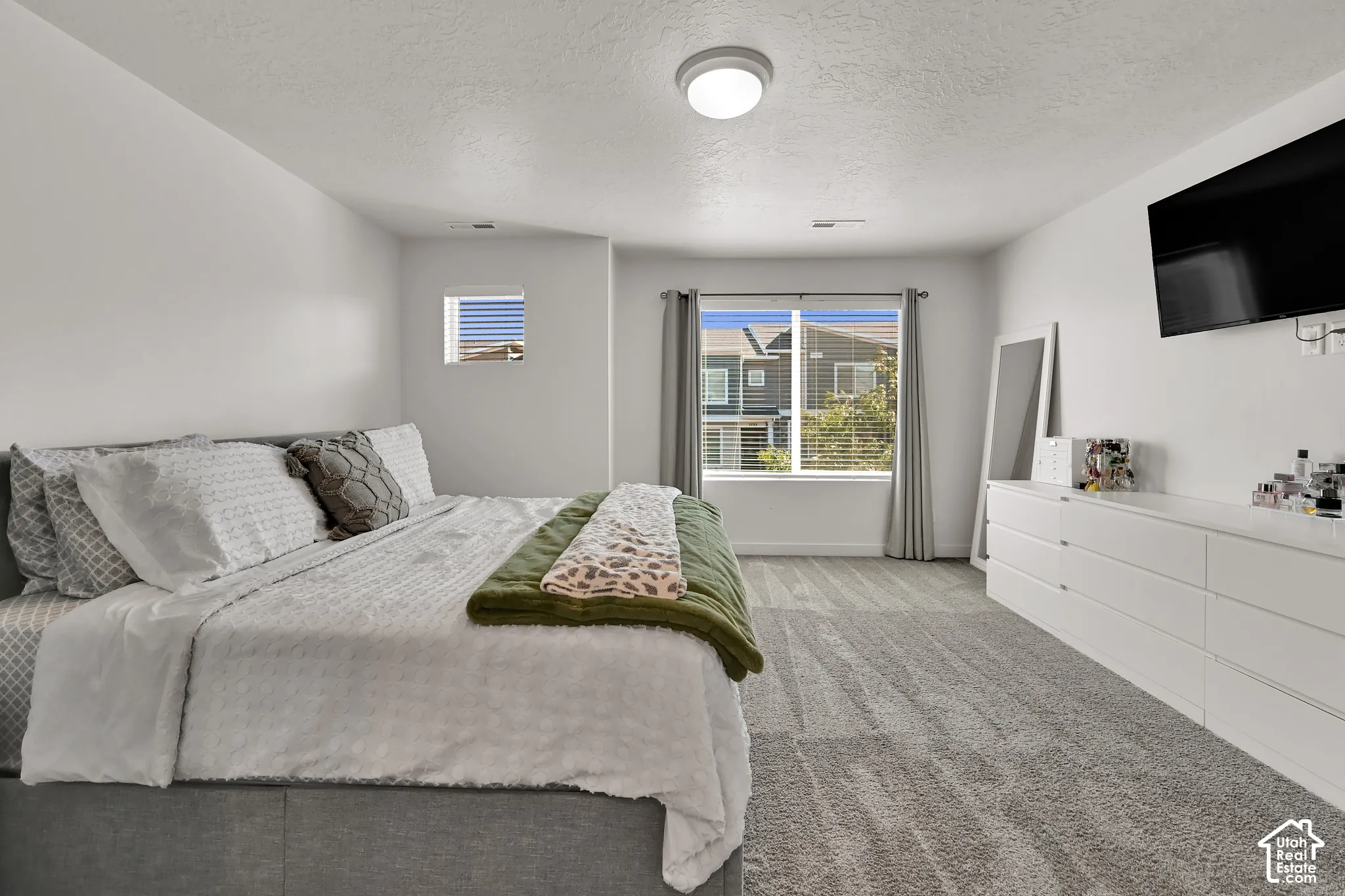 Spacious room featuring carpeting, multiple windows, and a flush mount lighting fixture