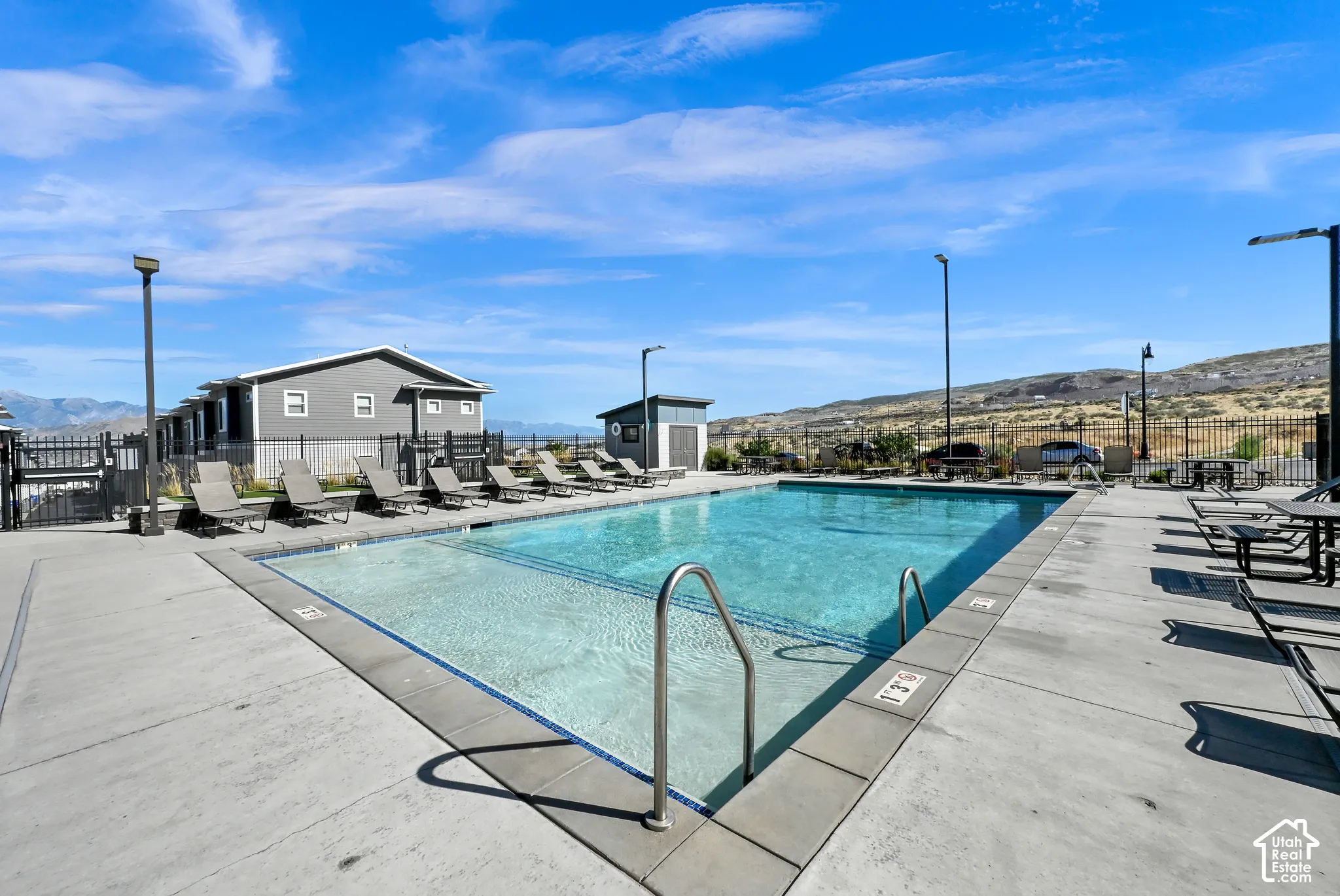 Outdoor swimming pool featuring a concrete deck and surrounding fencing