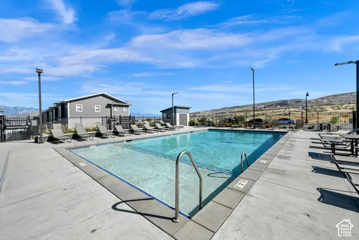 Outdoor swimming pool featuring a concrete deck and surrounding fencing