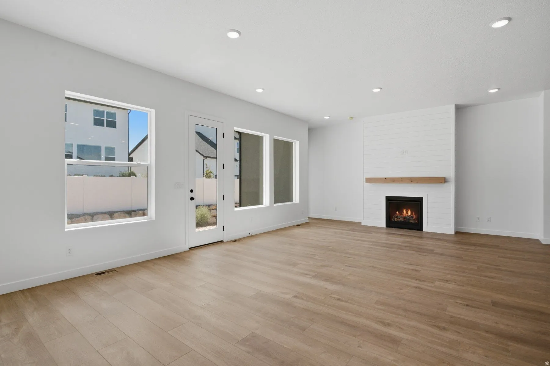 Wood-finish flooring, recessed lighting, and white walls
