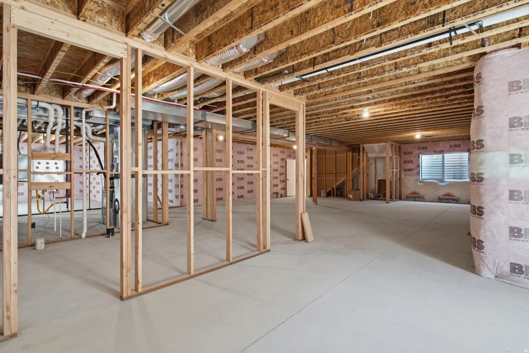 Unfinished lower level featuring wood framing, exposed ceiling joists, and concrete flooring