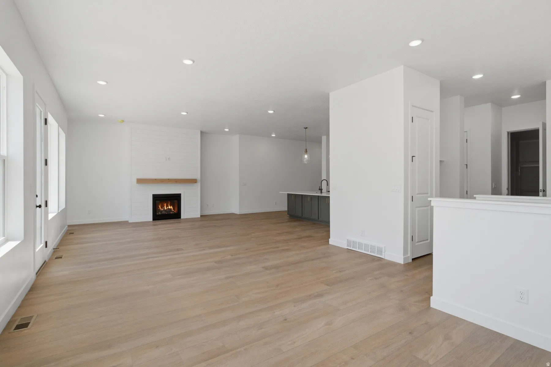Wood-finish flooring throughout, recessed lighting, and white walls