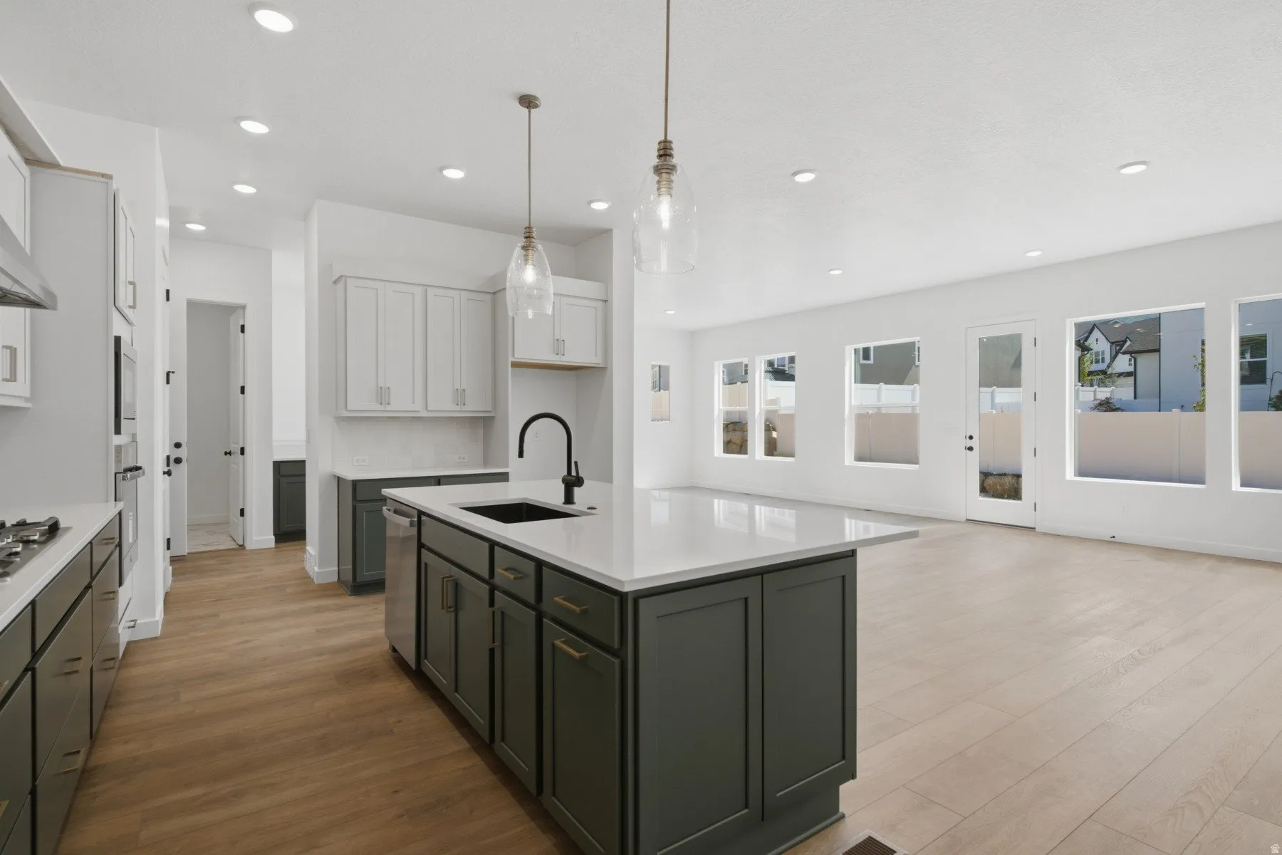 Contemporary kitchen island with a dark finish, integrated sink, and white countertop