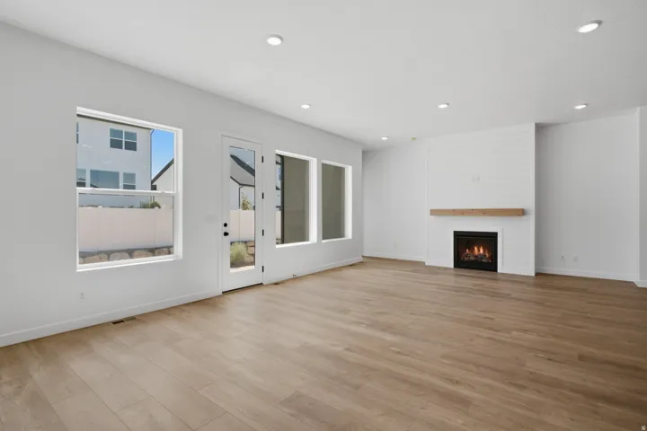 Wood-finish flooring, recessed lighting, and white walls