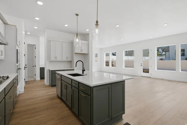 Contemporary kitchen island with a dark finish, integrated sink, and white countertop