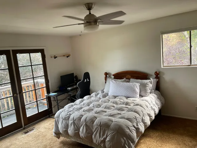 Room featuring French doors, a ceiling fan with integrated lighting, a window, and wood-finish flooring