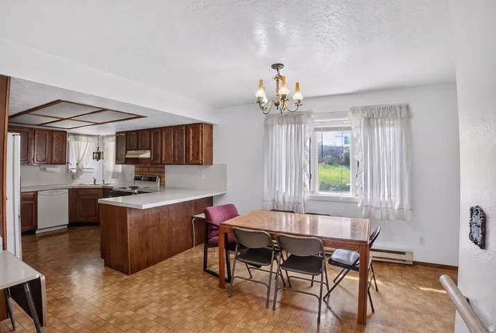 Kitchen featuring wood cabinetry, white appliances, white countertops, and a brick-finish backsplash