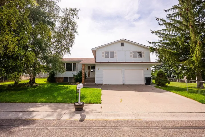 Two-story residence with light-colored siding, a two-car garage, and a concrete driveway
