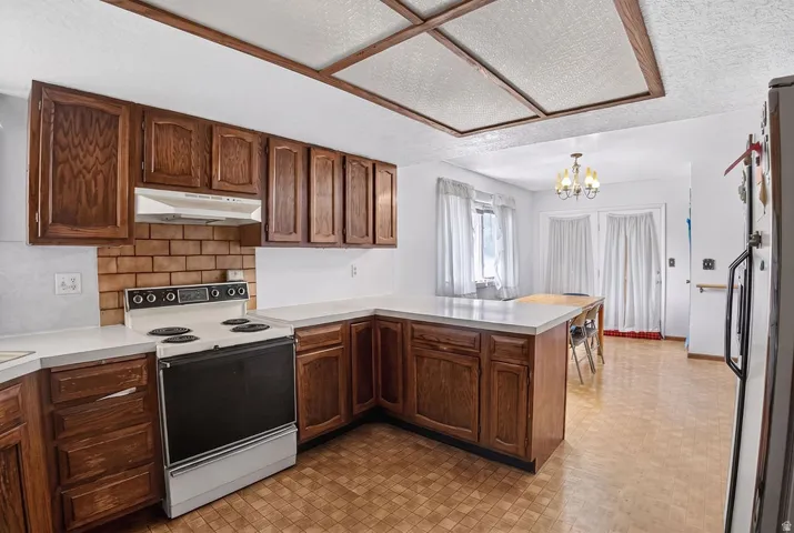 Spacious kitchen featuring rich wood cabinetry, stainless steel appliances, and a large center island with seating