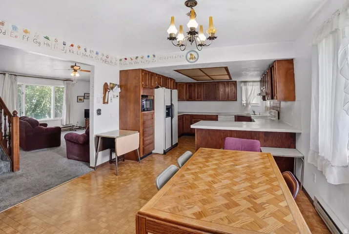 Kitchen with wood cabinetry, light countertops, and a ceiling-mounted light fixture