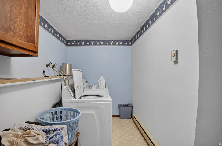 Laundry area with a built-in wood-finish cabinet and tiled flooring
