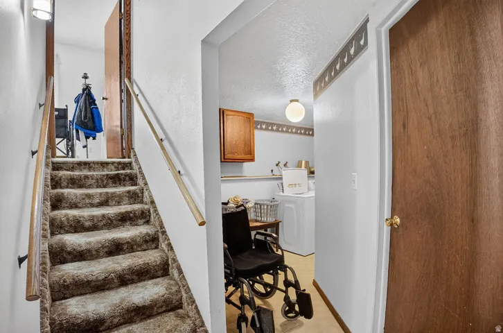 Staircase with carpeted treads and natural wood handrails