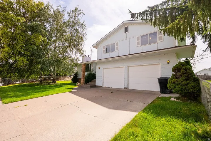 Two-car garage, light-colored siding, and a concrete driveway