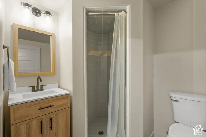 Wood-finish vanity with a white countertop and undermount sink