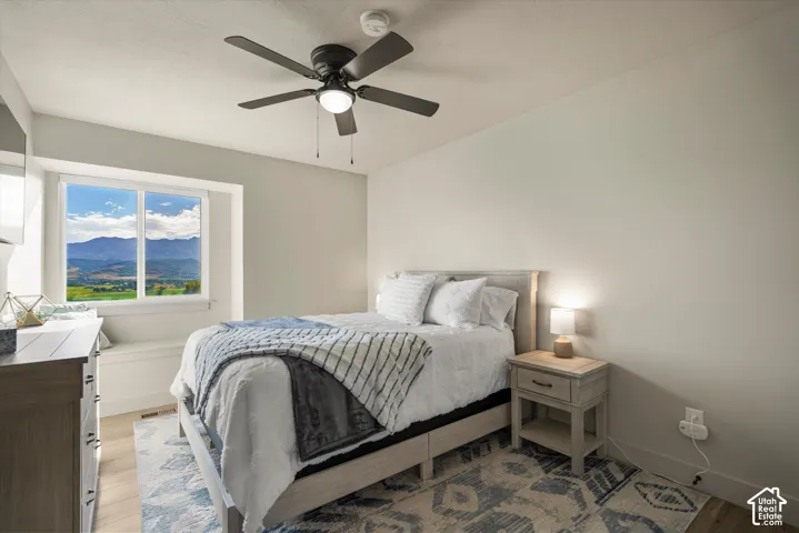 Recessed window with built-in seating, wood-finish flooring, and a ceiling fan with integrated lighting