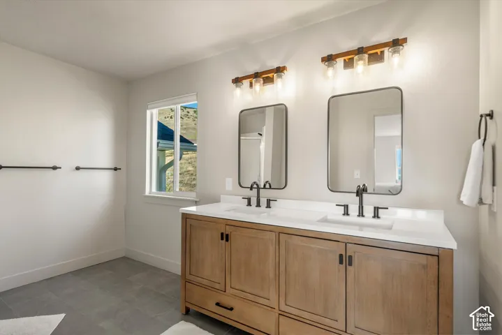 Dual vanity with wood-finish cabinetry, white countertops, matte black faucets, and rectangular framed mirrors