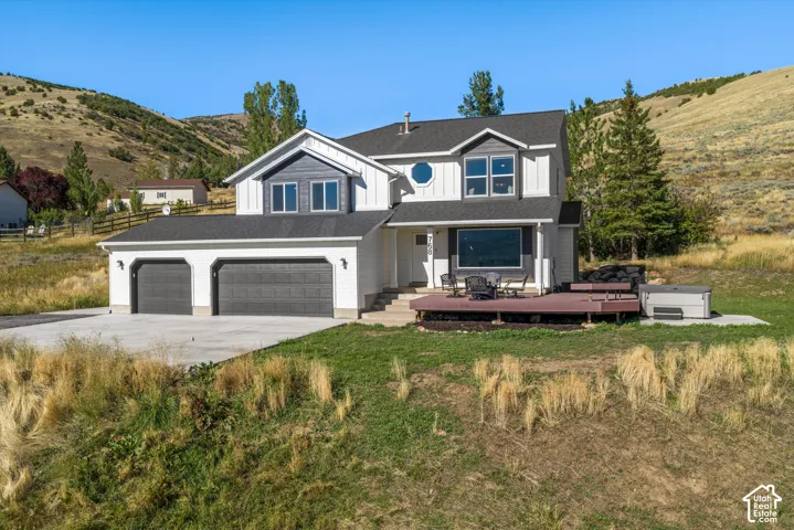 Two-story residence featuring a two-car garage, large deck, and distinct architectural elements including a prominent circular window