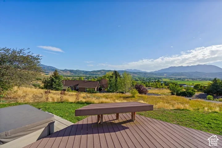 Expansive composite deck featuring built-in bench seating and a hot tub