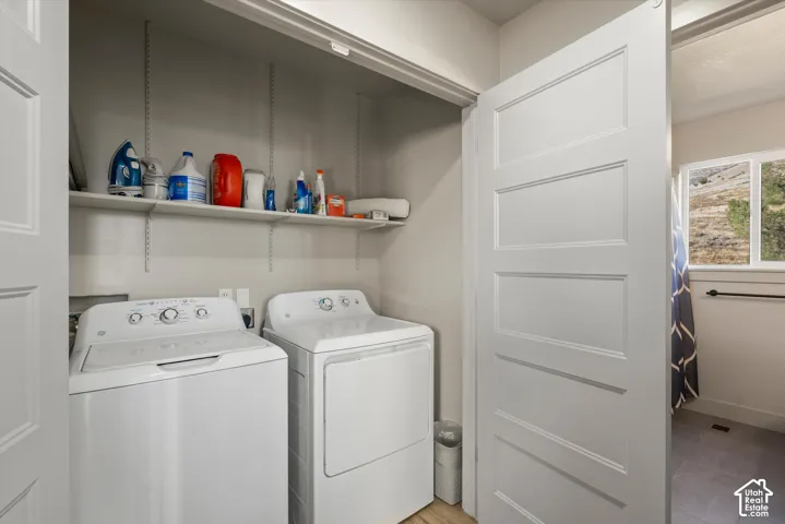 Dedicated laundry area with built-in shelving, top-load washer, and dryer
