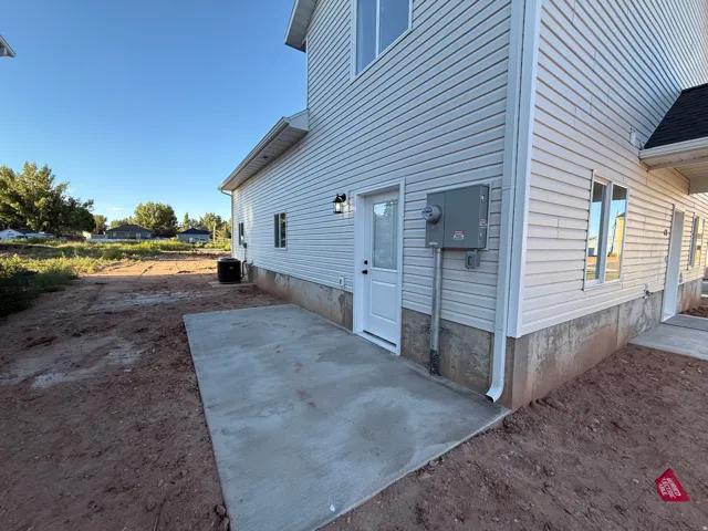 White siding exterior with a concrete patio