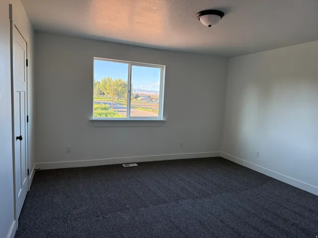 Carpeted flooring, white walls, white trim, and a flush mount light fixture