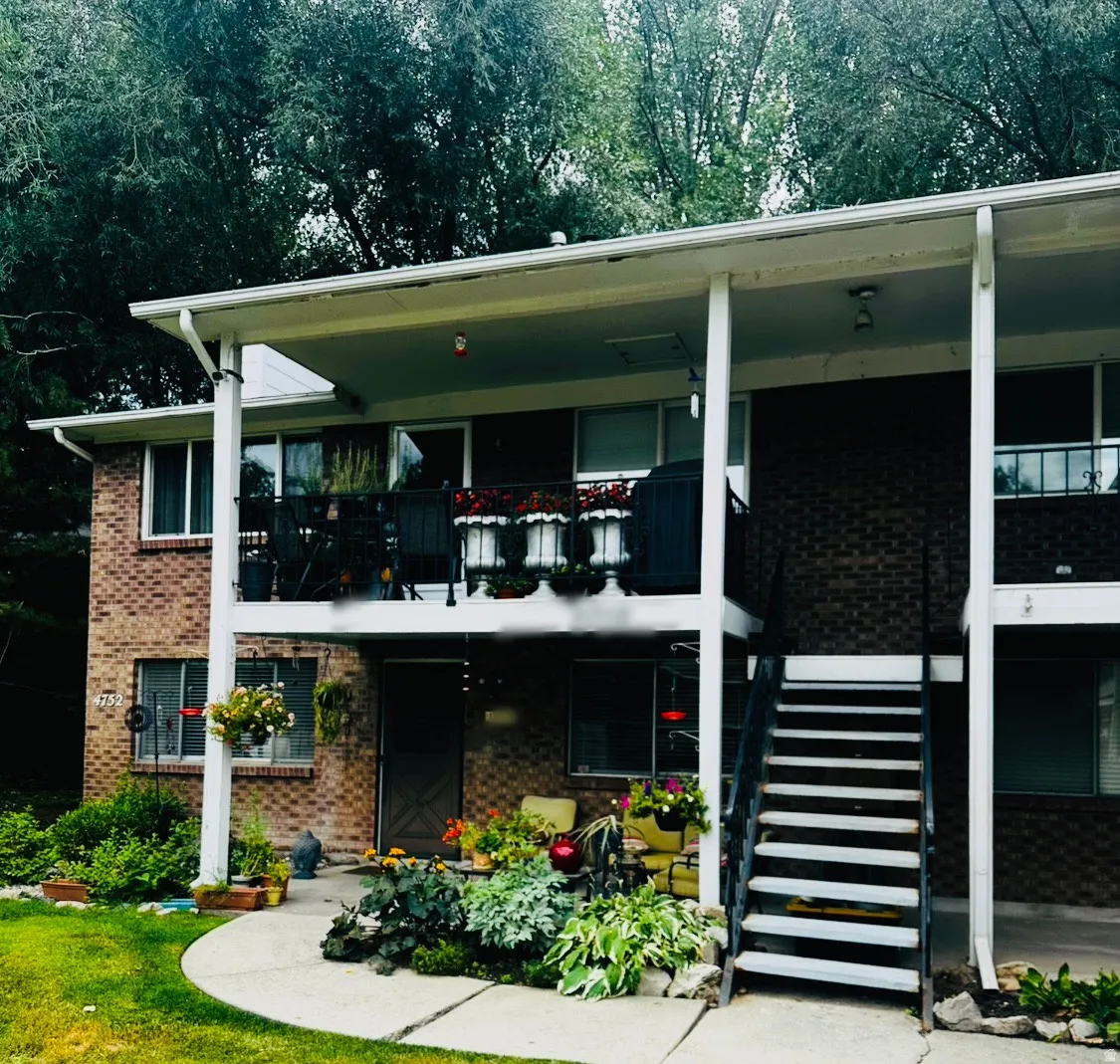 Brick exterior featuring multiple windows and a covered balcony