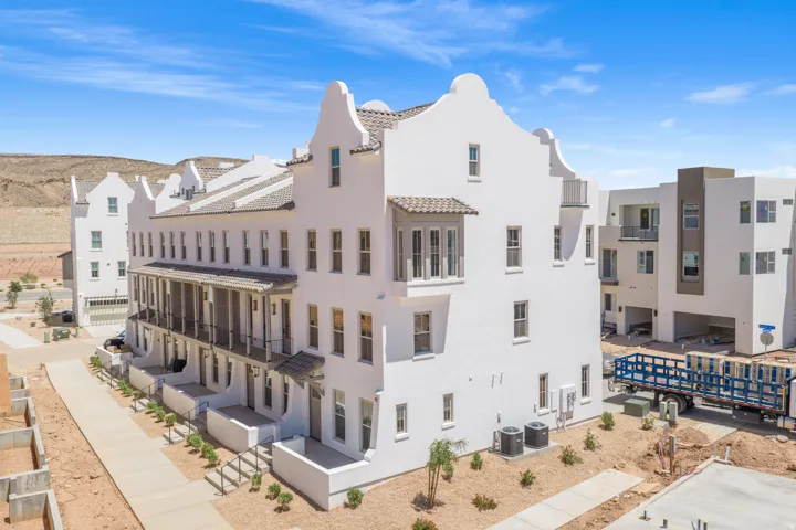 Multi-story residences featuring white stucco exteriors, arched rooflines, and multiple balconies