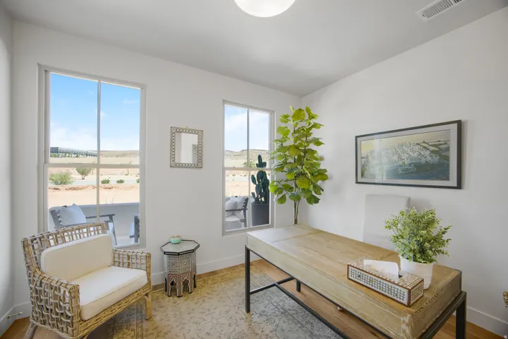 White walls with recessed ceiling lighting, light-colored wood-finish flooring, and multiple windows