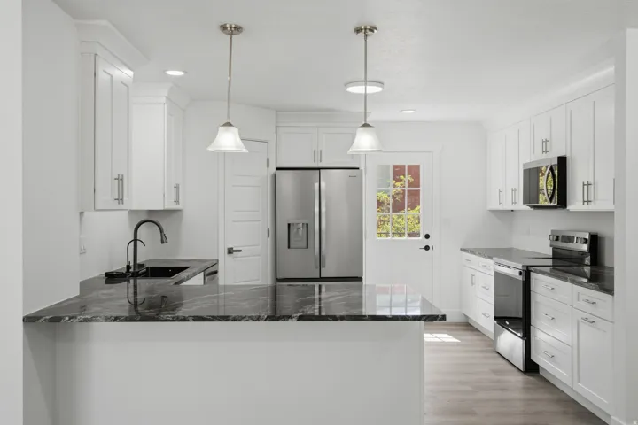 White shaker cabinetry, stainless steel appliances, and stainless steel appliances