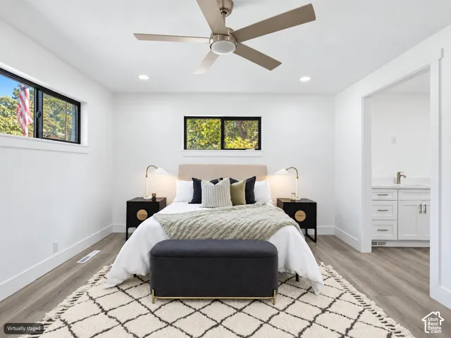 Wood-finish flooring, matte black window frames, ceiling fan with integrated lighting, and recessed ceiling lights
