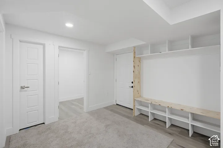 Built-in shelving inside garage door, extra storage rooms, and utility room in basement