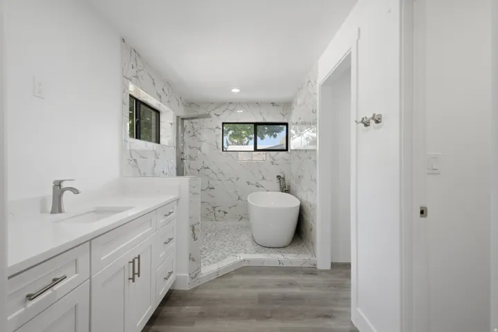 Classy freestanding soaking tub, walk-in shower with mosaic tile floor
