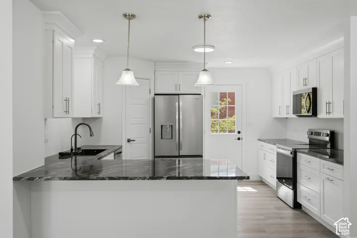 White shaker cabinetry, stainless steel appliances, and stainless steel appliances