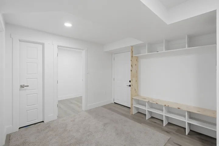 Built-in shelving inside garage door, extra storage rooms, and utility room in basement