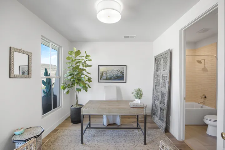 Well-lit interior space featuring wood-finish flooring, a contemporary flush mount ceiling light, and a window with a mountain backdrop