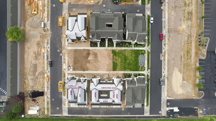 Newly constructed residential buildings featuring dark roofing and multiple gables