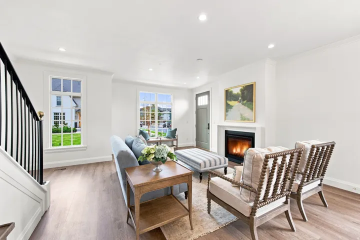 Wood-finish flooring, recessed lighting, and a built-in fireplace with a white mantel