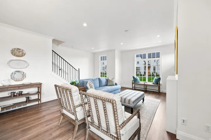 Spacious living area featuring wood-finish flooring, recessed lighting, and crown molding