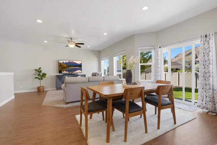 Open-concept living area with wood-finish flooring, recessed lighting, and a ceiling fan