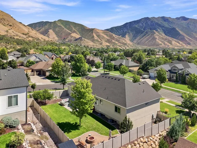 Expansive backyard with a manicured lawn, fire pit area, and established privacy fencing