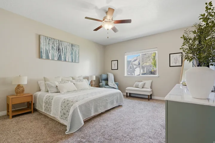 Carpeted room featuring a ceiling fan, a window, and painted walls