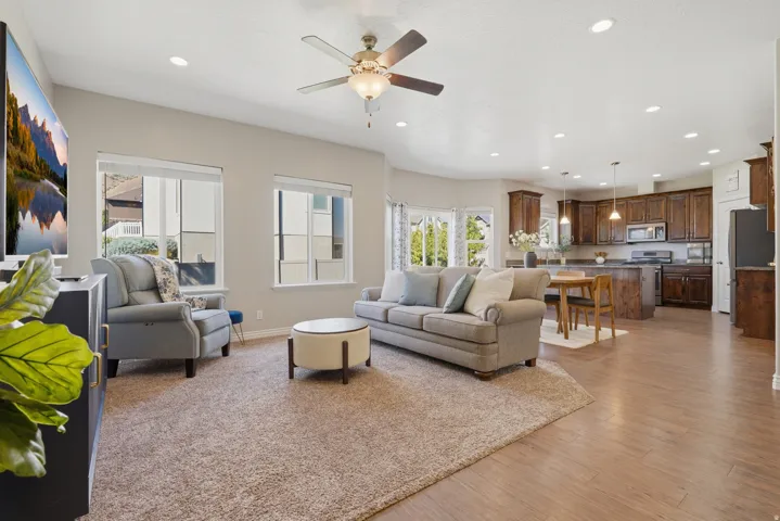 Open-concept living space featuring wood-finish flooring, recessed lighting, and a ceiling fan