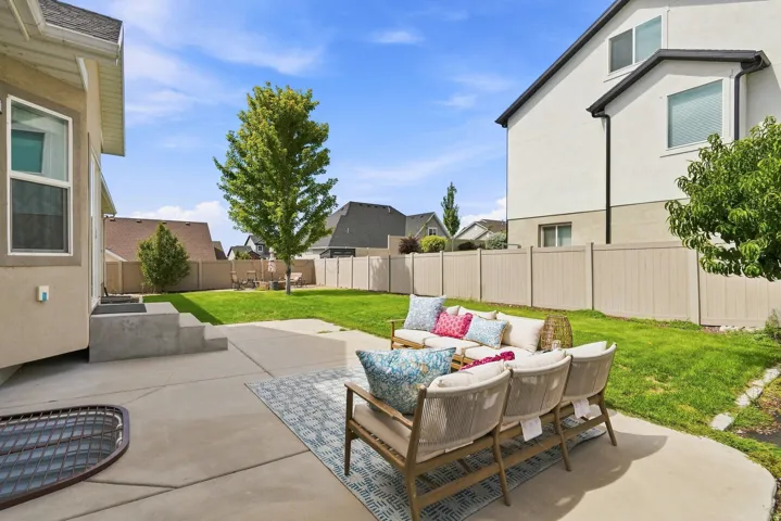 Expansive backyard featuring a concrete patio, a manicured lawn, and a privacy fence