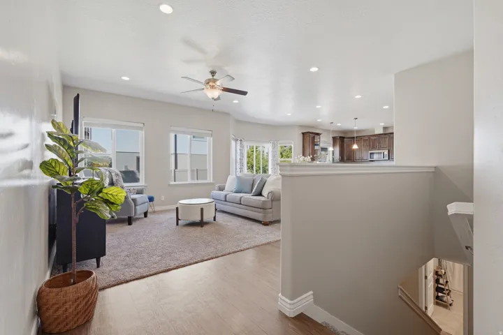 Open-concept living space featuring wood-finish flooring, recessed lighting, and a ceiling fan