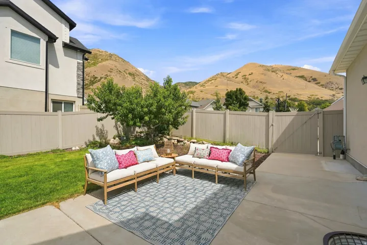 Expansive concrete patio with a perimeter fence, offering a backdrop of mountain scenery